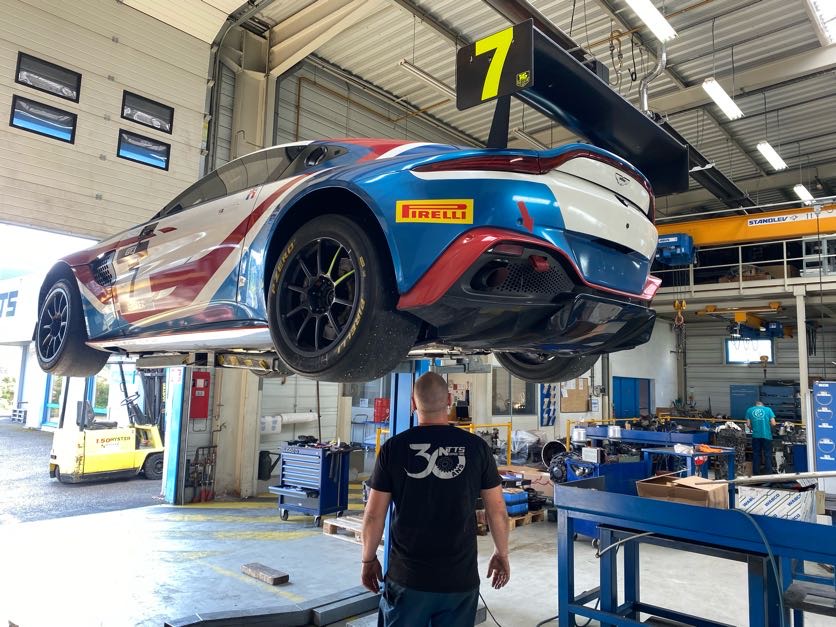 Voiture de course surélevée dans un Garage pour maintenance et entretien